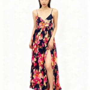 A woman in a Spaghetti Strap Floral Split Long Dress, size S, featuring a bright floral pattern and thigh-high slit, stands barefoot against a plain background.