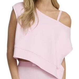 A woman wearing a light pink, asymmetrical one-shoulder crop top with matching high-waisted bottoms.