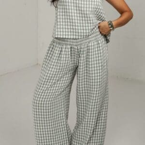 A person wearing a matching green and white gingham sleeveless top and wide-leg trousers with an elastic waistband.