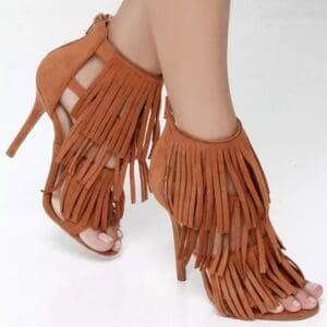 Tan high-heeled sandals with fringe detailing.