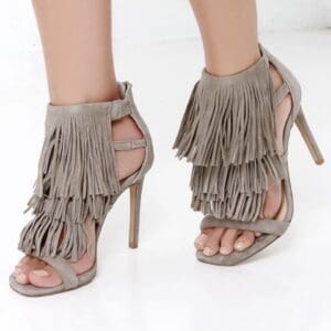 Taupe high-heeled sandals with layered fringe detail.